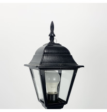 Вуличний ліхтар в чорному корпусі з прозорим склом на ніжці